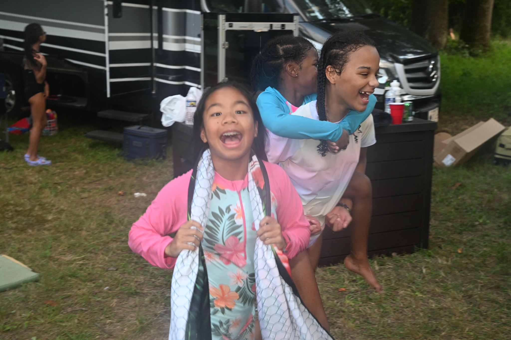 Girls laughing and goofing around in front of the RV — Campout 2023
