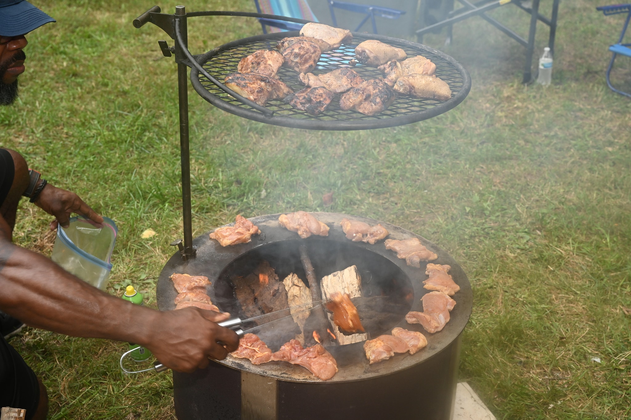 Close-up of chicken cooking on the two-level fire pit grill — Campout 2023