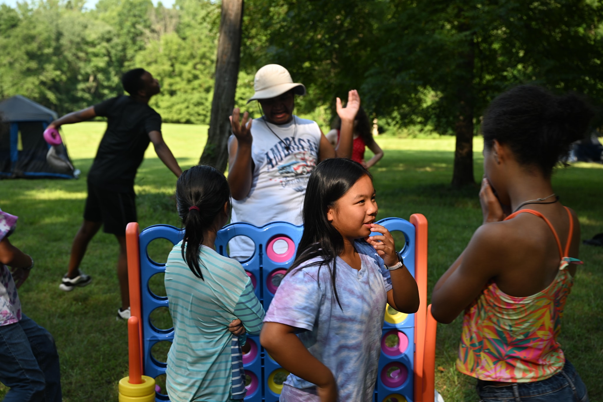 Kids playing and dancing around the giant Connect Four on the lawn — Campout 2024