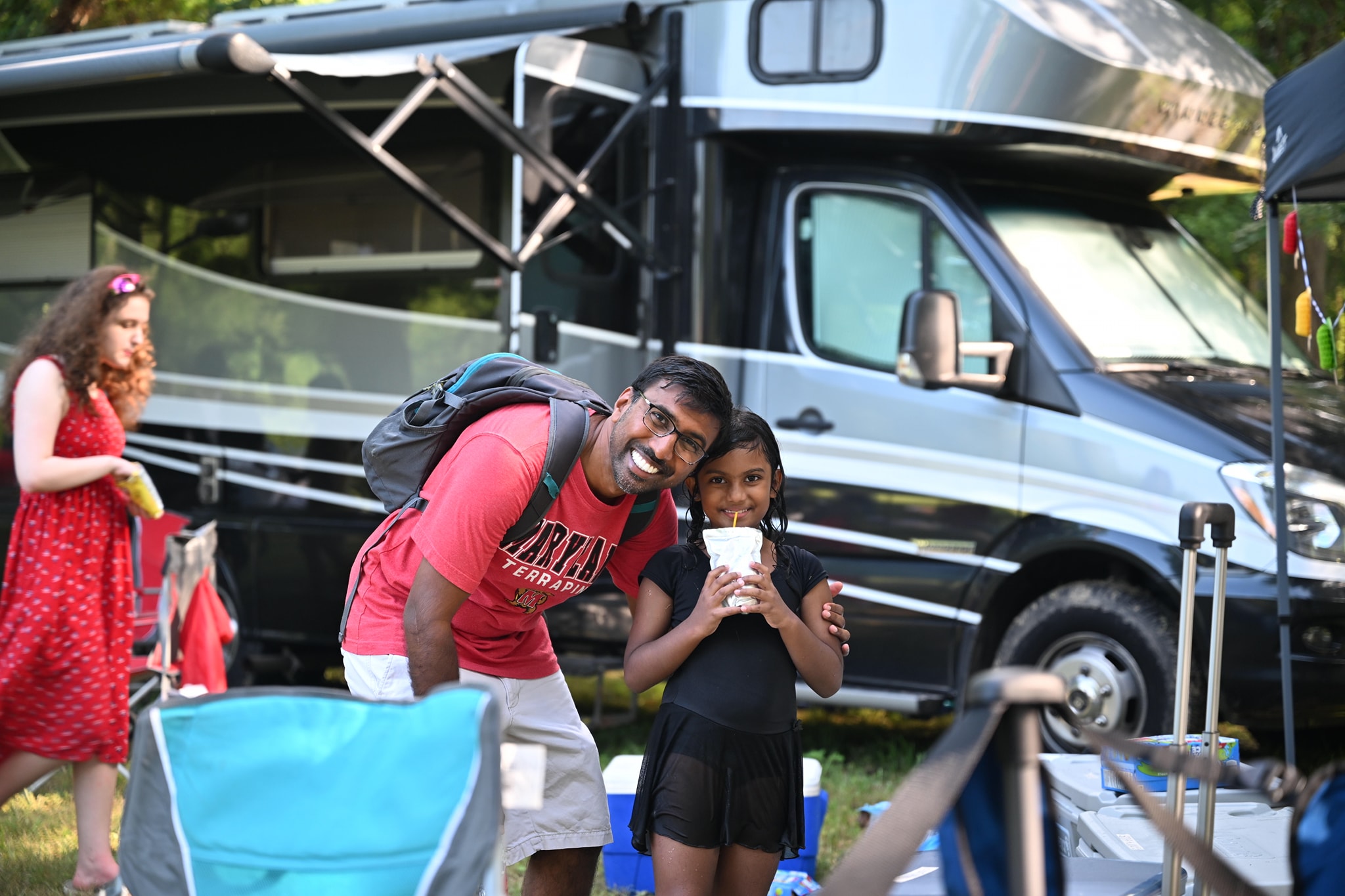 Smiling together in front of the RV in matching red and yellow — Campout 2024