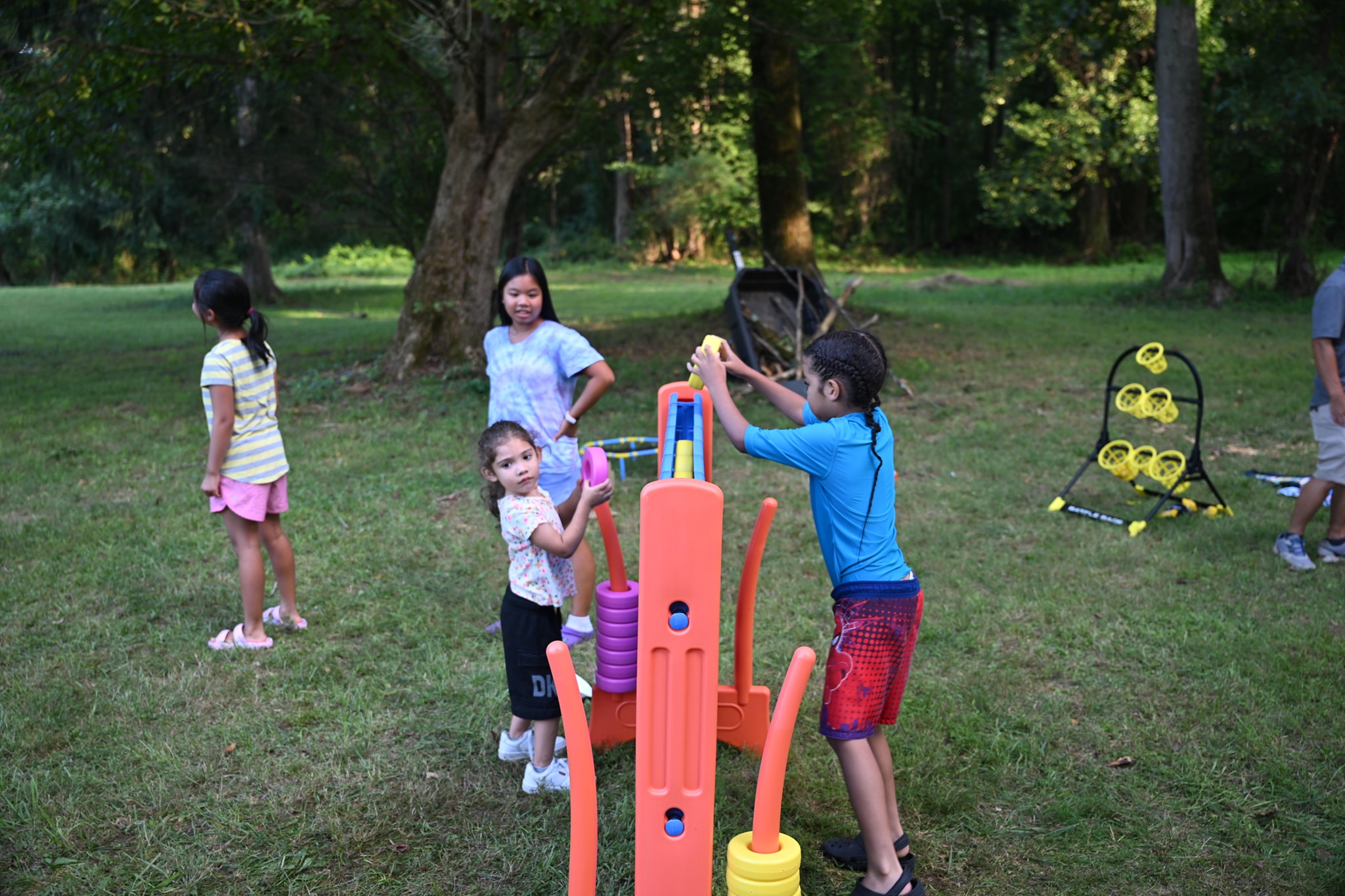 Kids playing with the lawn game set in the wooded backyard — Campout 2024