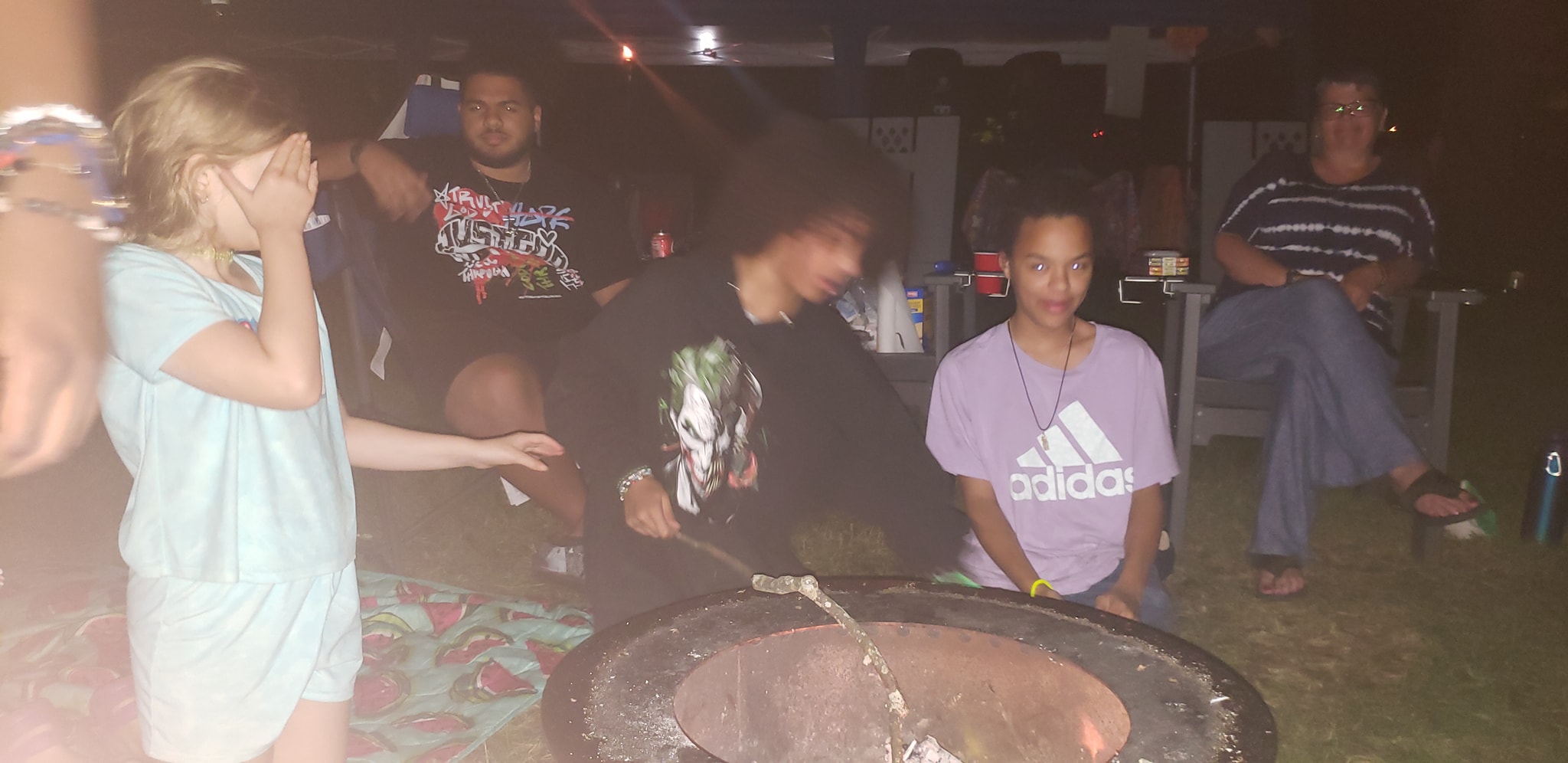 Guests gathered around the campfire pit late at night — Campout 2024