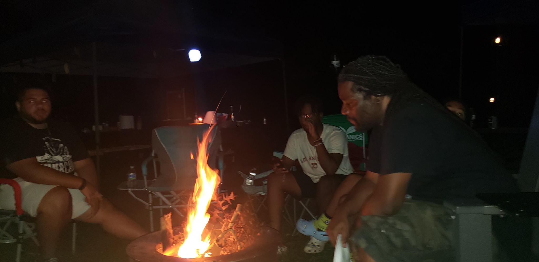 Guests gathered around the open campfire as it burns late into the night — Campout 2024
