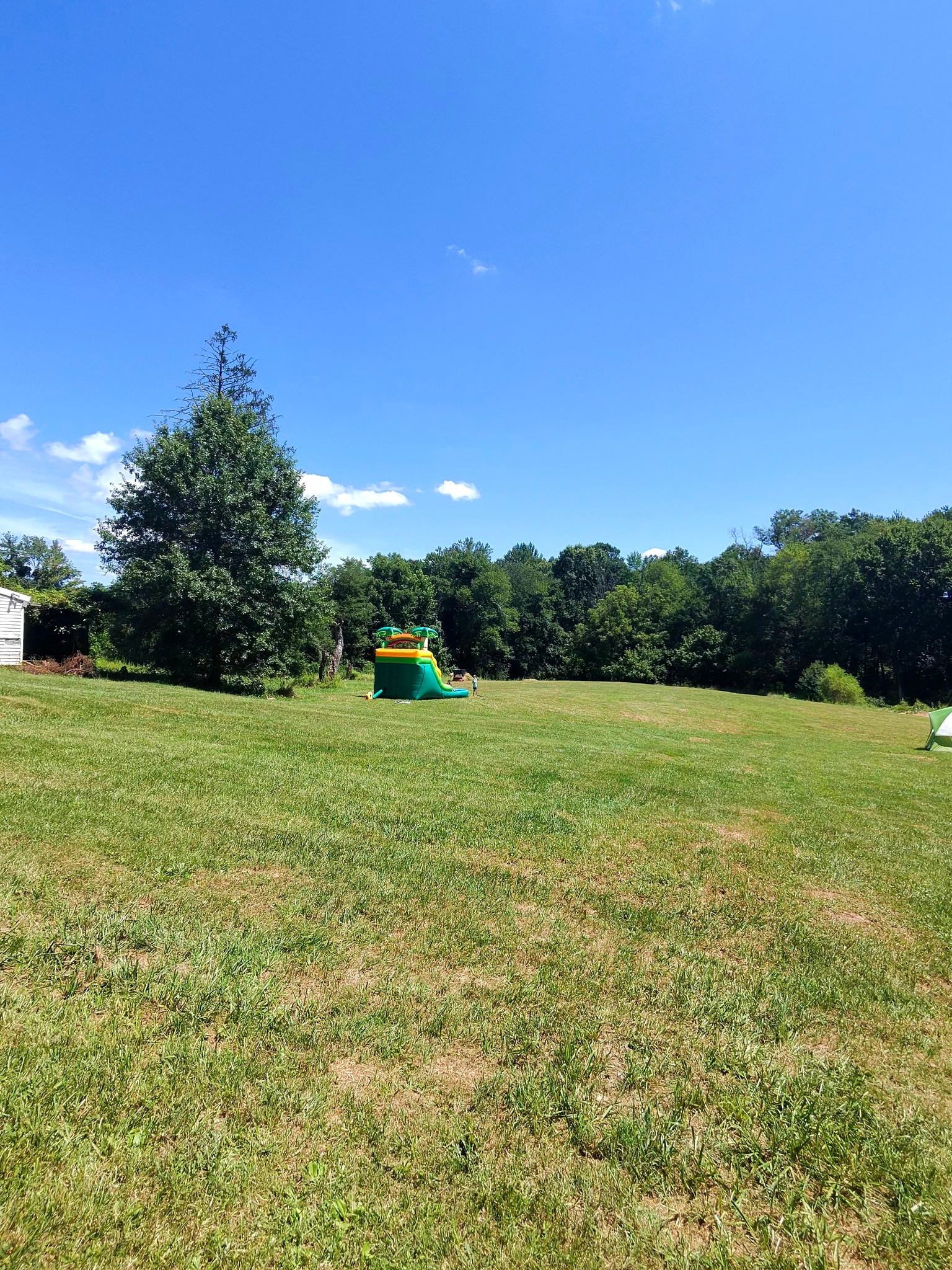 The open lawn with the inflatable water slide visible in the distance — Campout 2025
