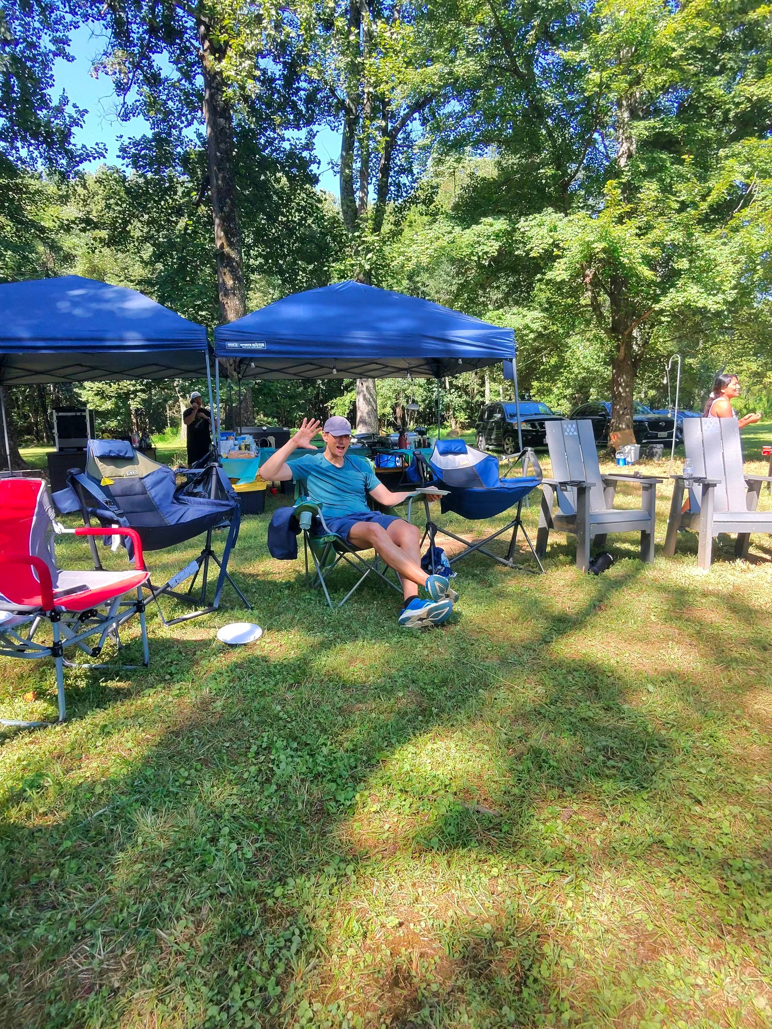 Relaxing in a camp chair and flashing a peace sign in the shade — Campout 2025