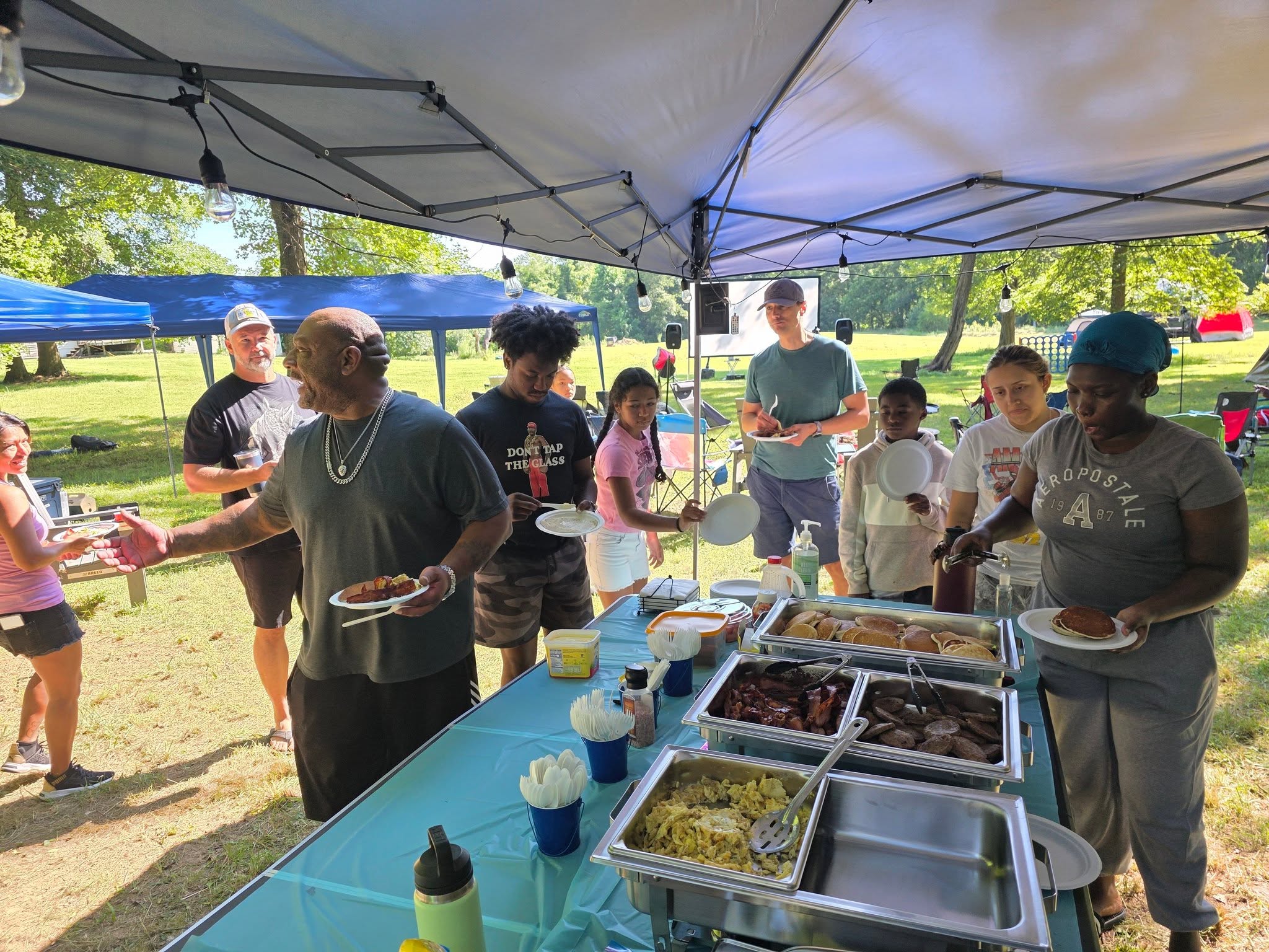 Guests lining up to fill their plates at the food canopy — Campout 2025