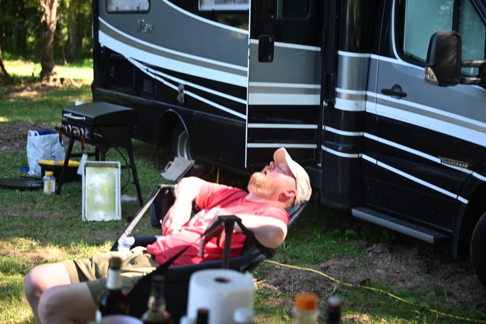 Reclining in a camp chair in the shade next to the RV — Campout 2025