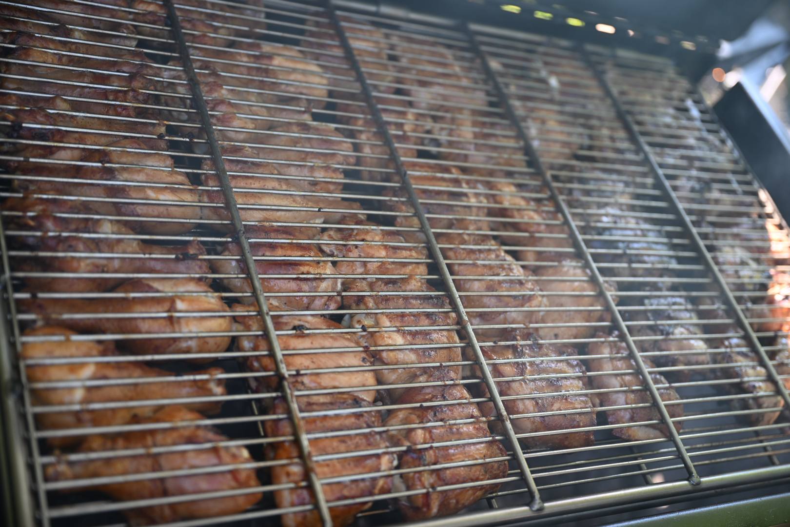 Racks of pork ribs filling the smoker grill from edge to edge — Campout 2025
