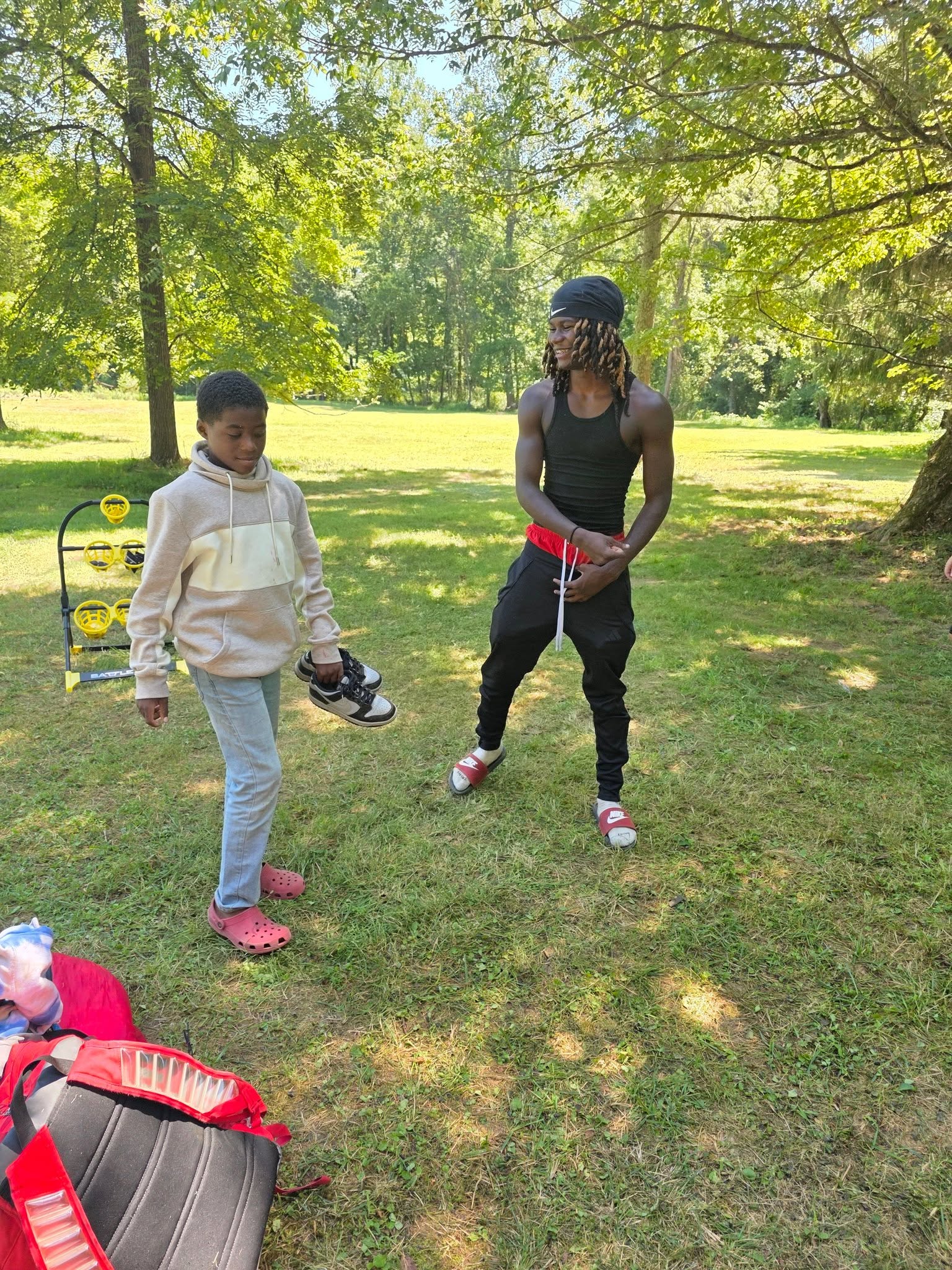 A young man and boy relaxing on the grassy lawn in afternoon sun — Campout 2025