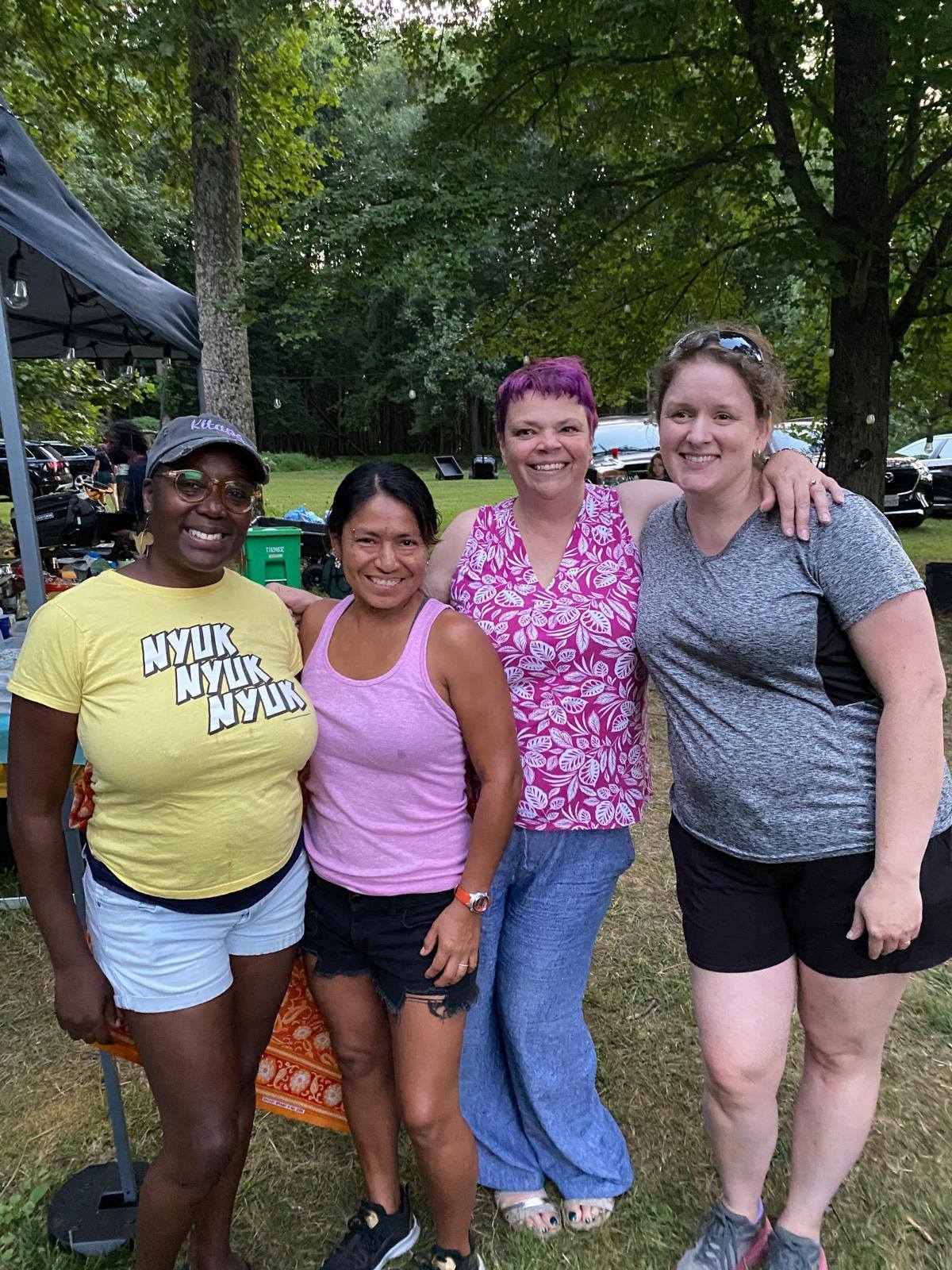 Guests smiling together in the wooded backyard on a sunny afternoon — Campout 2025